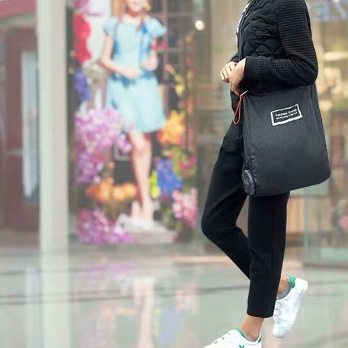 persona caminado por la calle usando bolsa plegable persona caminado por la calle usando bolsa plegable